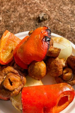 Izgara sebzeli domuz kebabı, kömürleşmiş mevsimlik ürünlerle taze eti birleştirerek doyurucu, dumanlı ve lezzetli bir yemek yaratır..