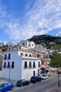 FRIGILIANA, SPAIN - 10 Mayıs 2025: Frigiliana, İspanya 'da beyazlatılmış evler ve renkli çiçeklerle çevrili büyüleyici dar sokaklarda huzurlu bir yürüyüş