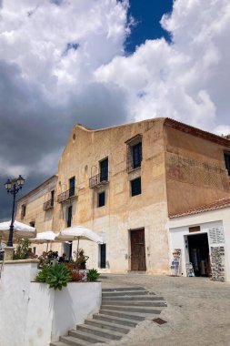 FRIGILIANA, SPAIN - 10 Mayıs 2025: Frigiliana, İspanya 'da beyazlatılmış evler ve renkli çiçeklerle çevrili büyüleyici dar sokaklarda huzurlu bir yürüyüş