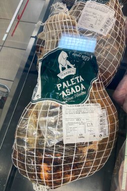 BENALMADENA, İspanya - 13 Aralık 2025: Terbiye edilmiş domuz bacağı taze ve İspanya 'nın Malaga kentindeki bir Carrefour süpermarketinde pişirilmeye hazır.