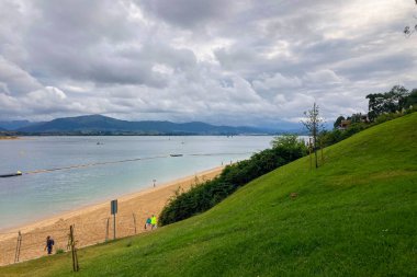 SANTANDER, İspanya - 19 Ağustos 2025: sakin deniz manzarası Santander, İspanya 'daki gezinti güvertesinden, yumuşak dalgalar ve huzurlu kıyı atmosferiyle.