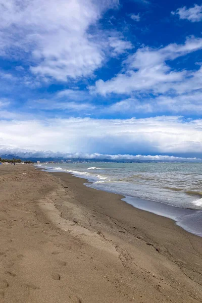 Yumuşak bulutlar sakin bir sahil üzerinde sürükleniyor, Akdeniz boyunca sakin bir kıyı havası yaratıyor..
