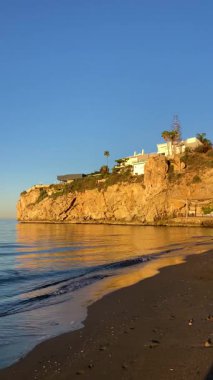 Muhteşem günbatımı, İspanya 'nın Rincon de la Victoria kentindeki El Cantal tünelleri yakınlarındaki kumsalı ve kayalık kıyı şeridini aydınlatıyor..