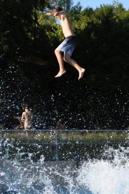 Laakirchen, Avusturya, Avrupa 'daki açık havuzda banyo ve zıplama.