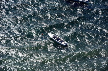 Rüzgarda bir şamandırada kayık ve yukarıda Traunsee 'de dalgalar