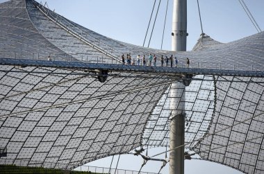 Münih 'teki Olimpiyat Stadyumu' nun çatısında turneye çıkan insanlar (Bavyera, Almanya, Avrupa)