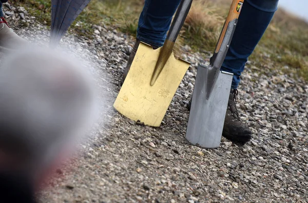 Bir binanın temel atma töreninde altın bir kürek.