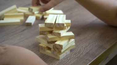 Çocuk ahşap parmaklıklardan bir kule inşa ediyor.