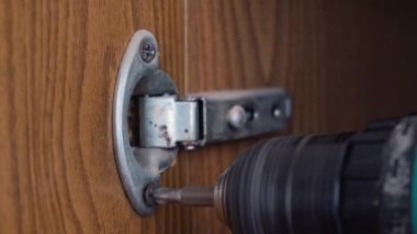 Tornavidalı bir adam eski mobilyaları söker.