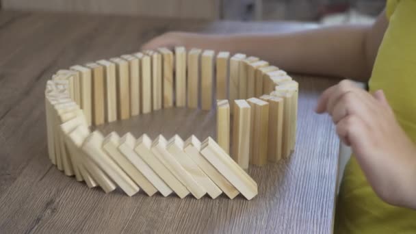 Het kind aan tafel begint een kettingreactie als domino-effect — Stockvideo