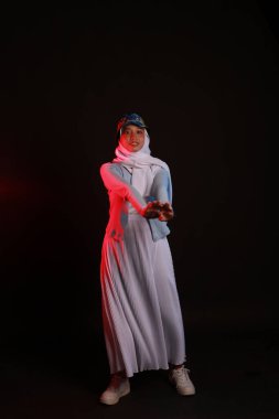 Mavi arka planda tesettürlü güzel Asyalı Müslüman kadının moda portresi.