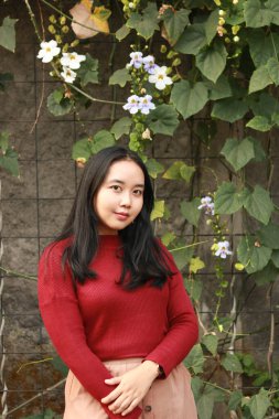 Genç ve güzel bir kadın kırmızı günlük tişört giyiyor..