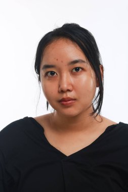 Beyaz arka planda makyajı olmayan genç Asyalı kadın..