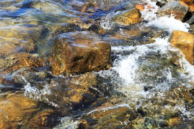 Sahildeki taşlar bir dalga tarafından yıkanır..