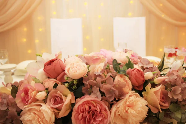 wedding table for the bride and groom decorated with flowers in pastel colors.