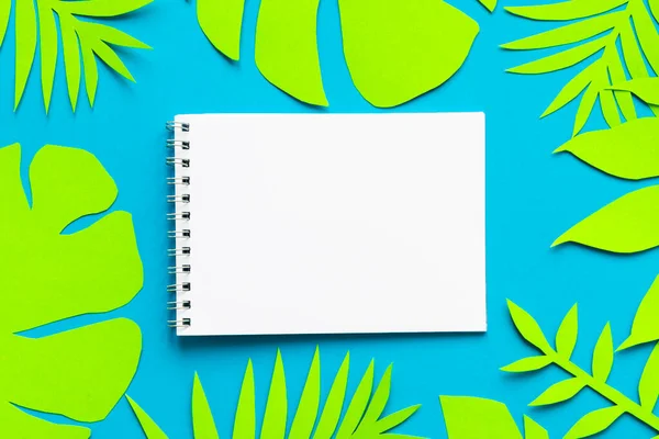 Concept hello summer. Notepad on palm tree leaves. Paper art. Top view background. Flat lay. copyspace. Empty.