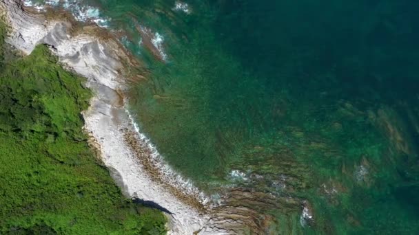 Vista aérea da costa rochosa do oceano com colinas verdes. — Vídeo de Stock