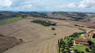 Evi, selvi yolu ve tepeleri olan Toskana kırsal arazisi. Hava görünümü.