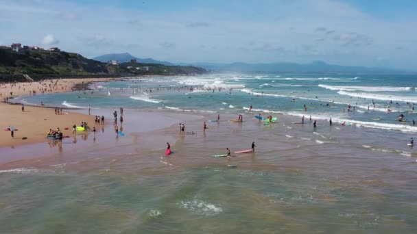 Molti surfisti con tavole vanno nell'oceano sulla costa di Biarritz. — Video Stock