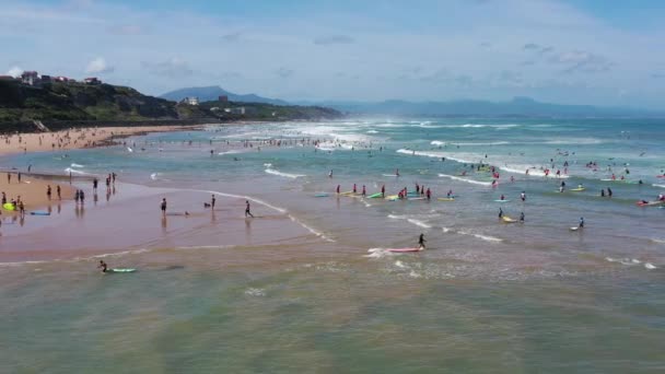 Muchos surfistas con tablas entran en el océano en la costa de Biarritz. — Vídeos de Stock