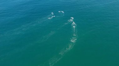 Bir grup insan jet ski ile denizde geziyor..