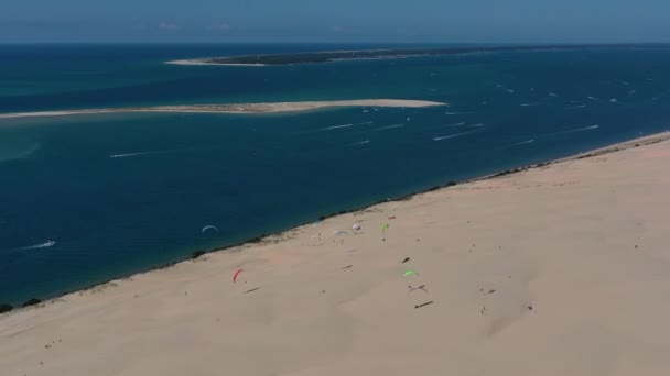 Los parapentes vuelan sobre la Duna de Pilat Dune du Pilat, Arcachon, Francia. La duna de arena más grande de Europa. — Vídeos de Stock