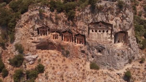 Luchtfoto van oude lycische graven uitgehouwen in de rots voor de adel, Turkije. — Stockvideo