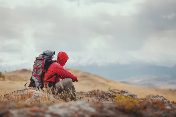 Adventure, travel, tourism, hike and people concept - man with backpack in mountain