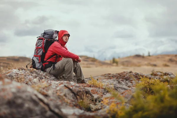 Adventure, travel, tourism, hike and people concept - man with backpack in mountain