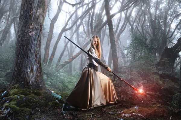 Young elf with magic staff in forest. Cosplay