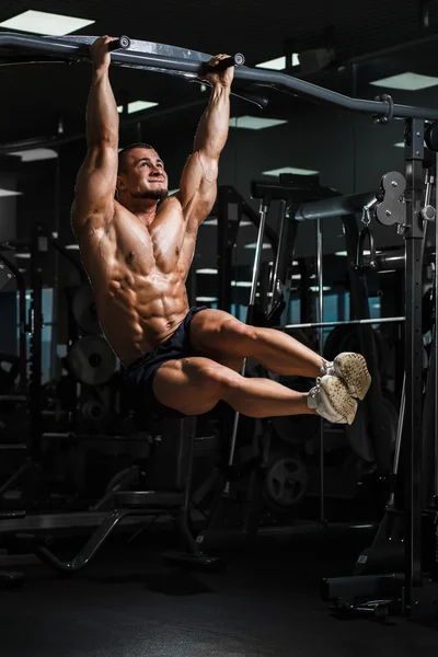 Athlete muscular fitness male model pulling up on horizontal bar