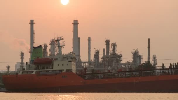 4 k time-lapse het schip voer de een olieraffinaderij met glanzende zon — Stockvideo