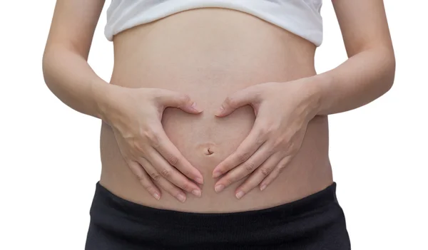 Mulher grávida formando coração fora de suas mãos, isolado contra fundo branco — Fotografia de Stock