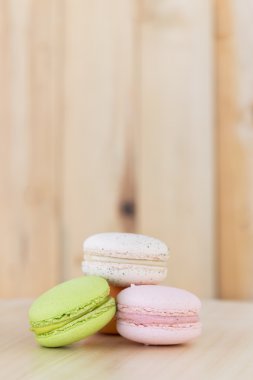 Renkli Macaron, ahşap arka plan üzerinde acıbadem kurabiyesi.