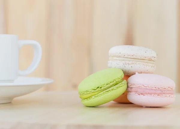 Tatlı Macaron, ahşap arka plan üzerinde cup ile acıbadem kurabiyesi.
