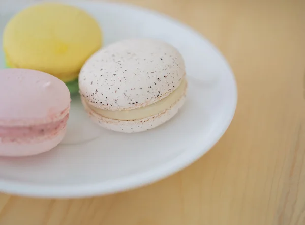 Closeup krem Macaron, ahşap arka plan üzerinde acıbadem kurabiyesi.