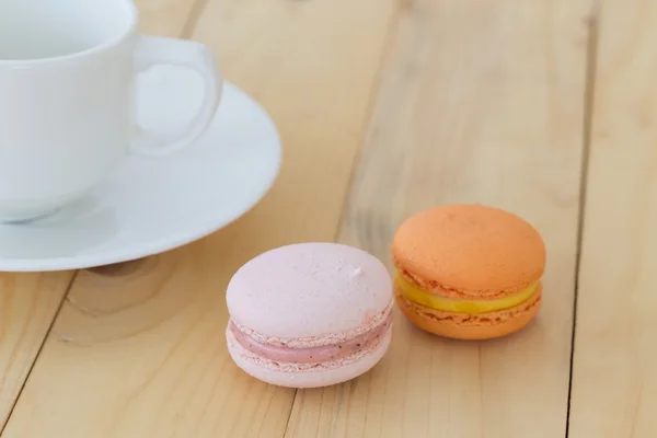 Macaron, Makronen mit Tasse auf Holzgrund. — Stockfoto