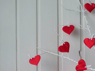 Beyaz ahşap bir arka planda kırmızı kalpler..