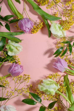 Pembe arka planda çiçek çerçevesi. Boşluğu kopyala, üst görünüm, düz uzanma.