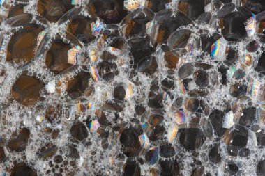 Büyük sabun köpükleri ve renkli yansımaları olan soyut koyu arkaplan. Kapat..