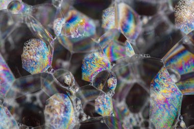 Büyük sabun köpükleri ve renkli yansımaları olan soyut koyu arkaplan. Kapat..