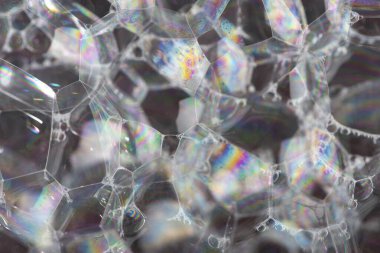 Büyük sabun köpükleri ve renkli yansımaları olan soyut koyu arkaplan. Kapat..