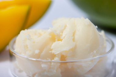 Mango yağı ve taze mango meyvesi yakın plan. Organik kozmetik, cilt bakımı, spa konsepti. Ev yapımı kozmetik ürünleri. Seçici odak.