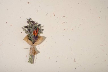 El yapımı kağıt arka planda bir buket kurumuş çiçek. Düz yerde, üst tarafta. Boşluğu kopyala.