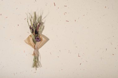 El yapımı kağıt arka planda bir buket kurumuş çiçek. Düz yerde, üst tarafta. Boşluğu kopyala.