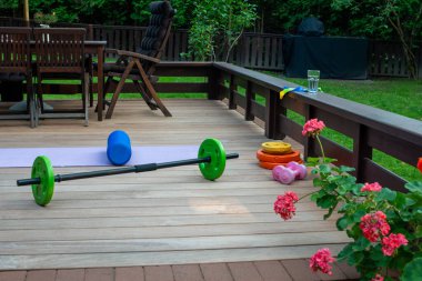 Ev bahçesi terasında ev eğitimi ekipmanları. Evde fitness var. Sağlıklı, eğitim ve yaşam tarzı kavramı.