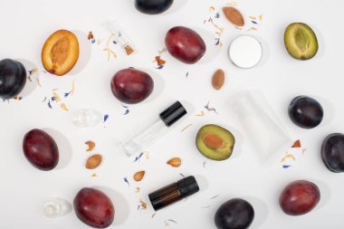 Kozmetik kaplar ve beyaz arka planda taze erikler. Düz yatış, üst görünüm.