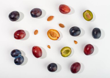 Beyaz arkaplanda erik meyveleri ve çekirdek bileşimi.