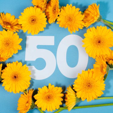 Mavi arka planda sarı gerbera çiçekleriyle çevrili 50 numara..