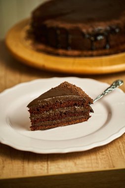 Tabakta bir dilim çikolatalı pasta. Lezzetli ev yapımı keklerle dolu bir masa.